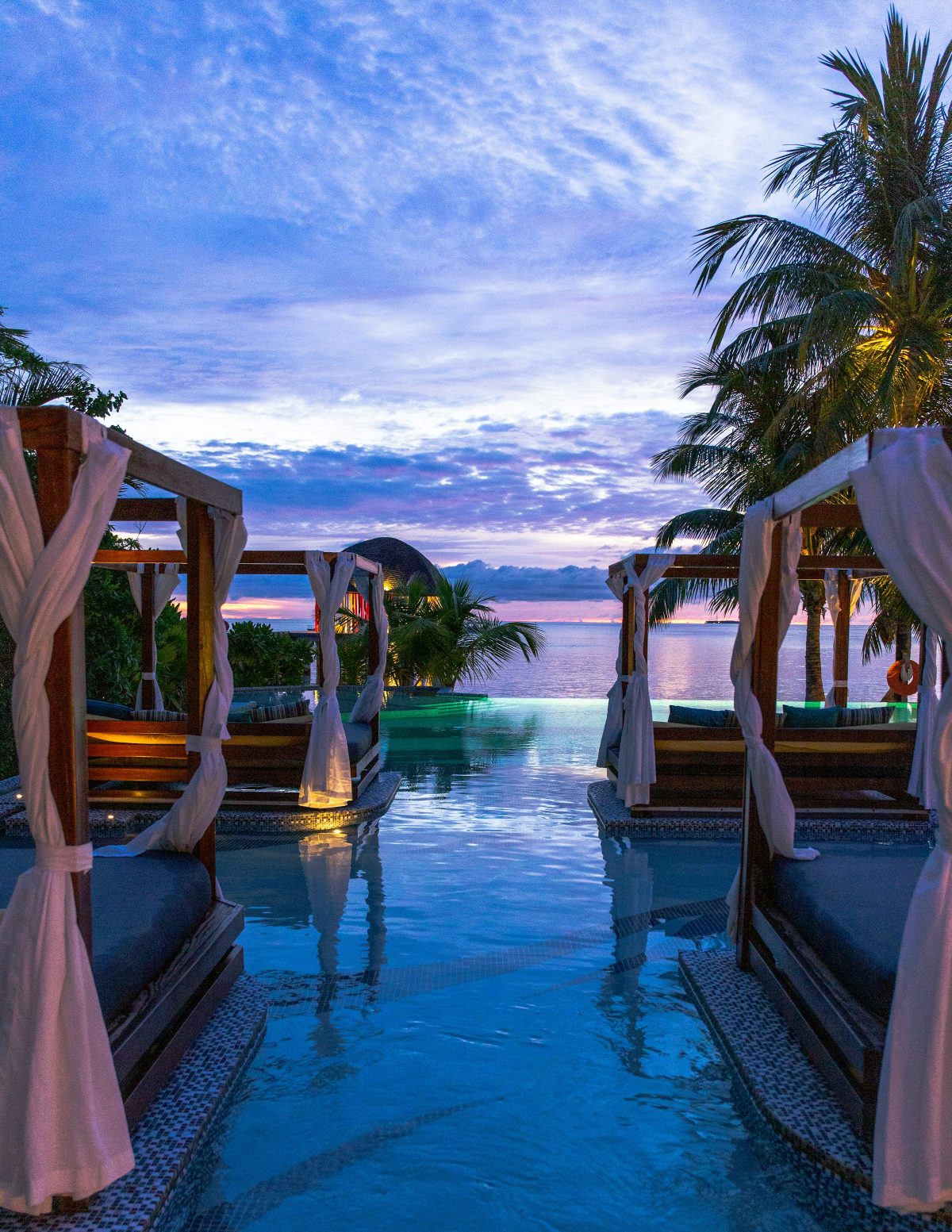 Infinity pool with cabanas at sunset